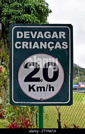 Geschwindigkeitsbegrenzung für Verkehrszeichen auf 20 km/h mit portugiesischen Wörtern, die LANGSAM KINDER bedeuten (devagar crianca) Stockfoto