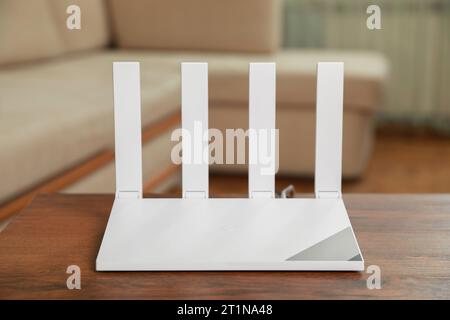 Neuer moderner WLAN-Router auf Holztisch im Innenbereich Stockfoto