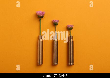 Schöne Blumen in Kugeln auf orangem Hintergrund, flach Stockfoto