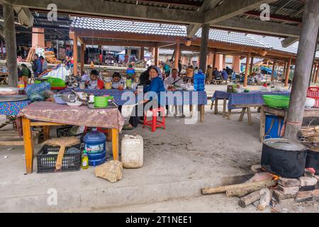 Cau Saturday Market, Hmong Woman serviert Kunden an ihrem Frühstücksbüfett. Provinz Lao Cai, Vietnam. Stockfoto