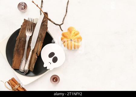 Halloween-Tisch mit leckeren Kürbisbrötchen und brennenden Kerzen auf hellem Hintergrund Stockfoto