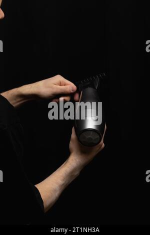 Haartrockner und Kamm in den Händen des Friseurs Stockfoto