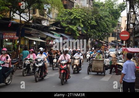 Motorroller und Motorräder in den belebten Straßen des historischen Zentrums von Hanoi, Vietnam Stockfoto