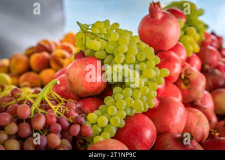 Frische Trauben und Granatäpfel in Kisten, die auf einem Bauernmarkt in San Francisco, Kalifornien, in loser Schüttung verkauft werden Stockfoto