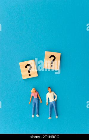 Frau und Mann Miniaturfigur und Fragezeichen Symbole Stockfoto