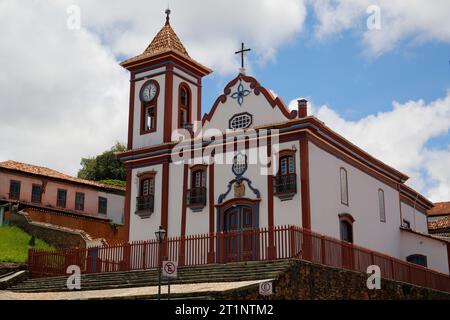 Blick auf die historische Kirche in weiß und Rot, mit blauem Himmel und weißen Wolken, Diamantina, Minas Gerais, Brasilien Stockfoto
