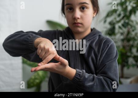 Wunderschönes, lächelndes, taubes Mädchen, das Gebärdensprache benutzt. Stockfoto
