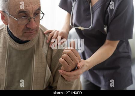 Krankenschwester, die Hand eines Seniorenmannes im Altersheim hält. Stockfoto