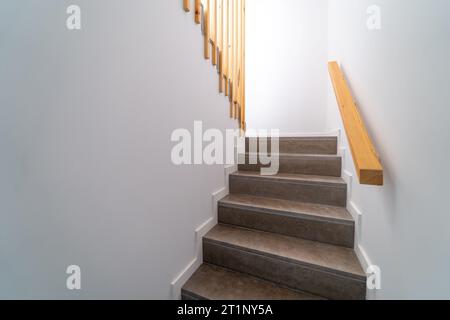 Moden Innentreppe aus Stein. Treppenaufgang geht runter. Pfad einer Treppe oder Treppe innerhalb eines Hauses. Innenraumdesign-Konzept. Stockfoto