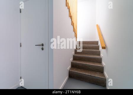 Moderne Innentreppe mit Staufach darunter. Treppenaufgang geht runter. Pfad einer Treppe oder Treppe innerhalb eines Hauses. Innenraumgestaltung im Innenbereich Stockfoto