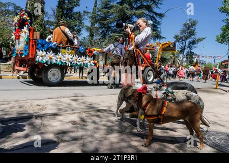 Villa General Belgrano, Argentinien. Oktober 2023. Ein Fotograf in Lederhosen und mit Hunden an der Leine fotografiert die Oktoberfestparade. Quelle: Diego Lima/DPA/Alamy Live News Stockfoto