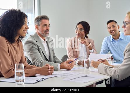 Mitarbeiter aus verschiedenen Geschäftsteams, die sich bei einer Besprechung im Büro unterhalten. Stockfoto