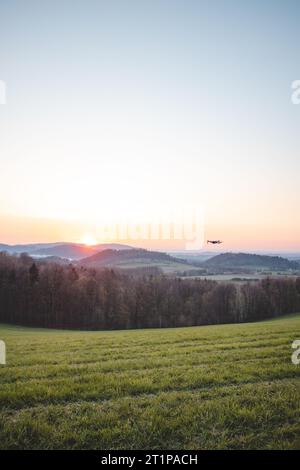 Mobile Drohne bei der Arbeit bei Sonnenuntergang. Technologische Innovation in Fotografie und Luftfahrt. Videoaufzeichnung aus der Luftaufnahme. Fliegendes Gerät. Stockfoto