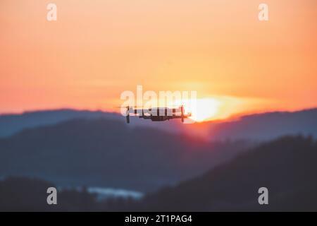 Mobile Drohne bei der Arbeit bei Sonnenuntergang. Technologische Innovation in Fotografie und Luftfahrt. Videoaufzeichnung aus der Luftaufnahme. Fliegendes Gerät. Stockfoto