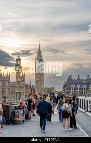 London, Großbritannien: 16. September 2023: Touristen auf der Westminster Bridge bei Sonnenuntergang mit dem Palace of Westminster im Hintergrund Stockfoto