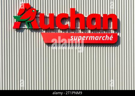 Auchan-Logo und Beschilderung auf der Fassade des Supermarktes - Ligueil, Indre-et-Loire (37), Frankreich. Stockfoto