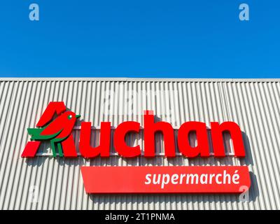 Auchan-Logo und Beschilderung auf der Fassade des Supermarktes - Ligueil, Indre-et-Loire (37), Frankreich. Stockfoto