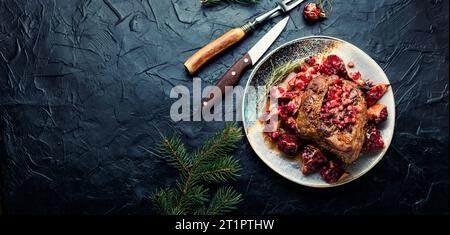Schmackhaftes Stück Schweinelende in einer fruchtigen Marinade. Gebratenes Fleisch mit Granatapfel. Speicherplatz kopieren Stockfoto