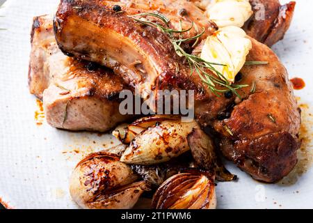 Appetitlich gebratenes Schweinefleisch auf dem Knochen und karamellisierte Zwiebeln. Gebratener Schweinelende. Stockfoto