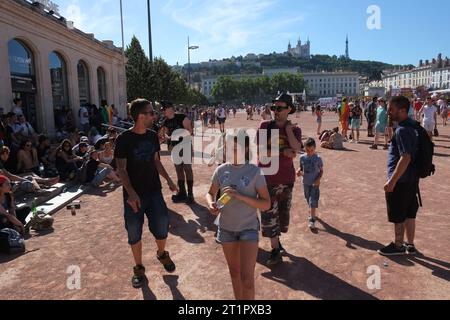 Menschen in Place Bellecour nach einem Gay Right, Pride Marsch und Party in Lyon, Frankreich - Blick über den großen öffentlichen Platz bis zur Notre Dame de Fourvière Stockfoto