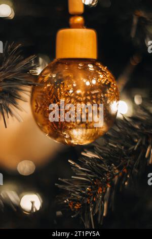 Weihnachtsbaum mit goldenem, glänzendem Weihnachtsspielzeug mit goldenen Sternen. Winterfeier. Die zauberhafte Wintertapete für das neue Jahr Stockfoto