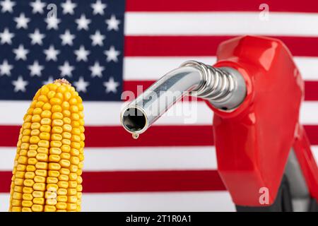 Gas tropft aus der Kraftstoffdüse mit amerikanischer Flagge und Maisohr. Benzinknappheit, Preis und Ethanolkonzept. Stockfoto