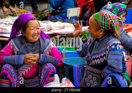 Bac Ha, Vietnam. Hmong Frauen in traditioneller Kleidung sprechen auf dem Sonntagsmarkt. Provinz Lao Cai. Stockfoto