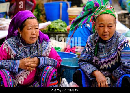 Bac Ha, Vietnam. Hmong Frauen in traditioneller Kleidung sprechen auf dem Sonntagsmarkt. Provinz Lao Cai. Stockfoto