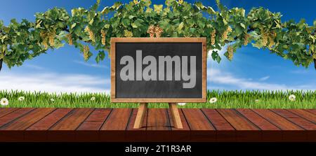Leerer Holztisch für Produktpräsentation mit leerer Tafel, defokussierte Landschaft mit Weinberg mit weißen Trauben und grünen Blättern. Stockfoto