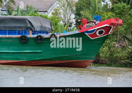 Flussverkehr auf dem Saigon River, in der Nähe von Ho Chi Minh, Vietnam. Schwarze Augen im White Circle auf dem Bug des Bootes sind traditioneller Schutz. Stockfoto