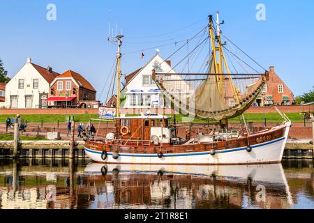 GREETSIEL, DEUTSCHLAND - 30. SEPTEMBER 2023: Garnelenboote vor Backsteinhäusern Stockfoto