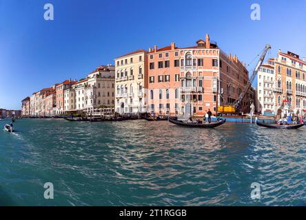 Venedig, Italien - 4. November 2022: An einem sonnigen Tag fährt eine Gondel mit Touristen entlang des Canal Grande vor dem Hintergrund historischer Gebäude. Stockfoto