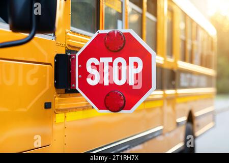 Nahaufnahme des verlängerten roten Stoppschildes im gelben Schulbus Stockfoto