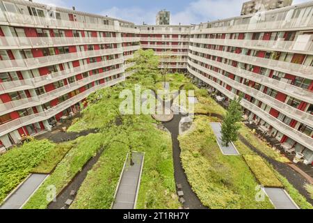 Ein Apartmentkomplex mit vielen Pflanzen auf dem Dach und Fußwegen, die in die obere Etage führen Stockfoto