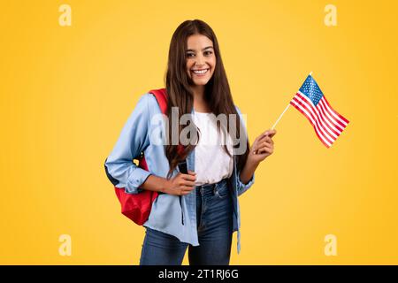 Positive kaukasische Teenager-Studentin mit US-Flagge verbindet Patriotismus mit Wissenschaft Stockfoto