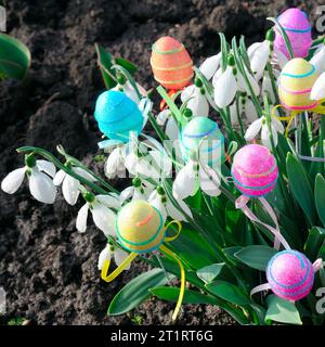 Schneeweiße Schneetropfen und dekorative Eier im Frühlingshintergrund. Osterkomposition. Stockfoto