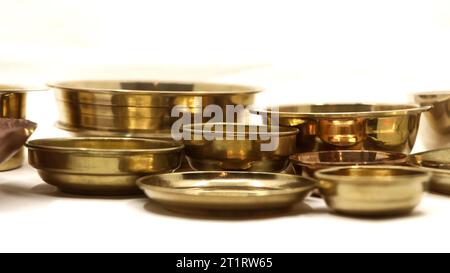 Nahaufnahme von alten antiken goldenen Schüsseltellern, die in einer Luxusküche verwendet wurden, isoliert auf einem weißen Hintergrund Stockfoto