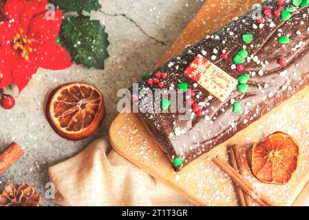 Traditioneller Weihnachtskuchen. Schoko Yule mit weihnachtsdekoration auf einem Holzbrett. Dessertkonzept für Weihnachten Stockfoto