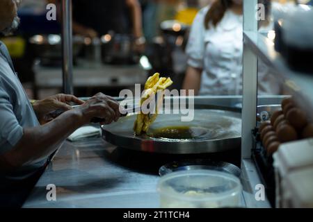 Roti-Herstellung, Roti-Dreschmehl vom Roti-Hersteller mit Öl. Thailändischer Pfannkuchen mit gesüßter Kondensmilch und dann mit Zucker bestreuen. Thai Street Foo Stockfoto