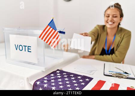 Junge, wunderschöne hispanische Frau, Wahlpräsidentin, die am Wahlkollegium abstimmt Stockfoto