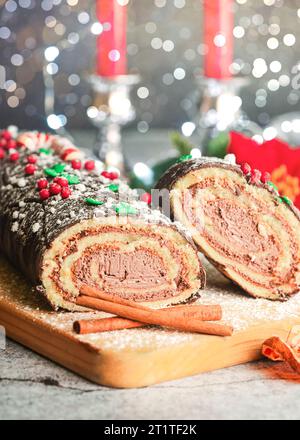 Traditioneller Weihnachtskuchen. Schoko Yule mit weihnachtsdekoration auf einem Holzbrett. Dessertkonzept für Weihnachten Stockfoto