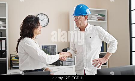Leitende Geschäftsleute und Architekt, die Dokumente lesen, schütteln sich im Büro die Hände Stockfoto
