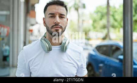 Junger arabischer Mann mit Kopfhörern auf der Straße Stockfoto