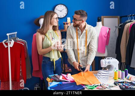 Mann und Frau Schneiderei Schneidertuch Schreiben auf Notebook in der Bekleidungsfabrik Stockfoto