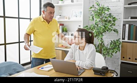 Ernsthafte Geschäftsleute streiten im Büro zusammen über Laptop, gestresst im Besprechungsraum Stockfoto