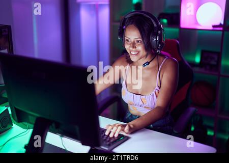 Junge hispanische Frau streamer lächelnd zuversichtlich, Videospiel im Spielsalon zu spielen Stockfoto