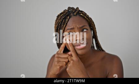 afroamerikanerin, die Pickel über isolierten weißen Hintergrund wirft Stockfoto