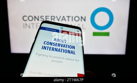 Mobiltelefon mit Website der Umweltorganisation Conservation International (CI) vor dem Logo. Fokussieren Sie sich oben links auf der Telefonanzeige. Stockfoto