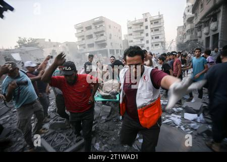 Rafah, Gaza. Oktober 2023. Palästinenser tragen einen verletzten Mann nach einem israelischen Angriff auf das Gebäude in Rafah im südlichen Gazastreifen am Sonntag, den 15. Oktober 2023. Die Vereinten Nationen berichteten, dass bereits mehr als 400.000 Palästinenser aus dem Norden des Gazastreifens geflohen sind, nachdem ein massiver israelischer Luftangriff mehr als 2000 Palästinenser getötet hat, die Hälfte davon Kinder und Frauen. Foto: Ismael Mohamad/UPI Credit: UPI/Alamy Live News Stockfoto