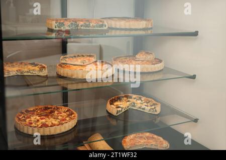 Verschiedene leckere Quiches auf der Theke im Laden Stockfoto